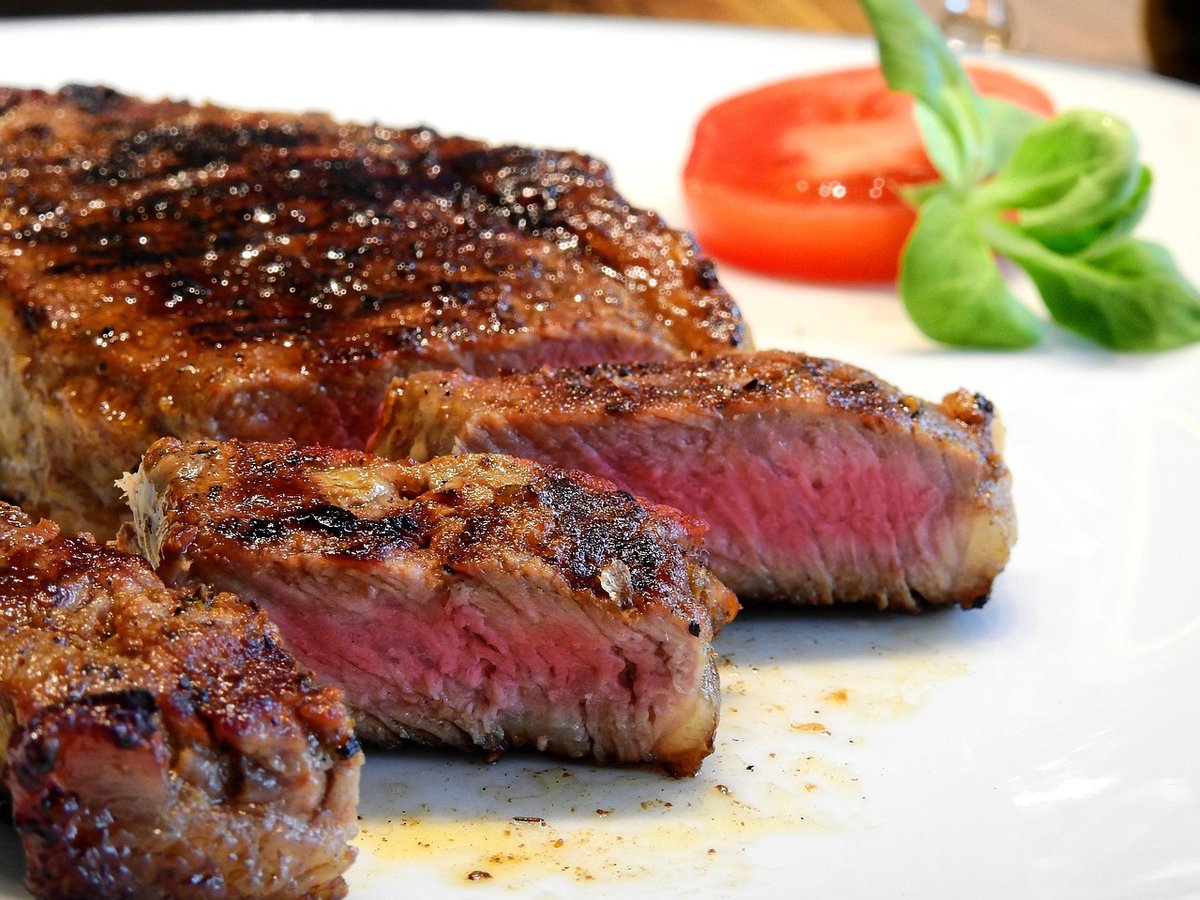 Cooked steak plated with garnish in a restaurant setting